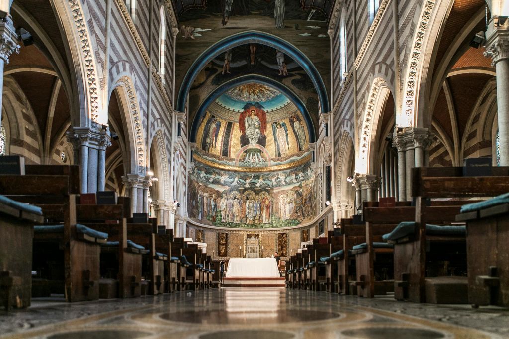 종교 예술품을 묘사한 장식된 압세, 아치형 콜로네이드, 퓨, 화려한 디테일이 돋보이는 대성당 내부.