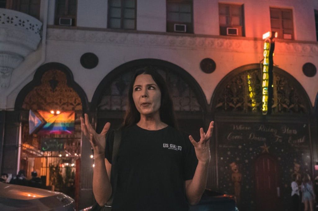 일행에게 자신의 이야기를 들려주며 손을 내미는 투어 가이드