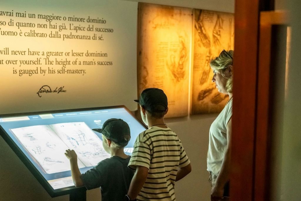 박물관 내부에서 터치 스크린과 상호 작용하는 가족