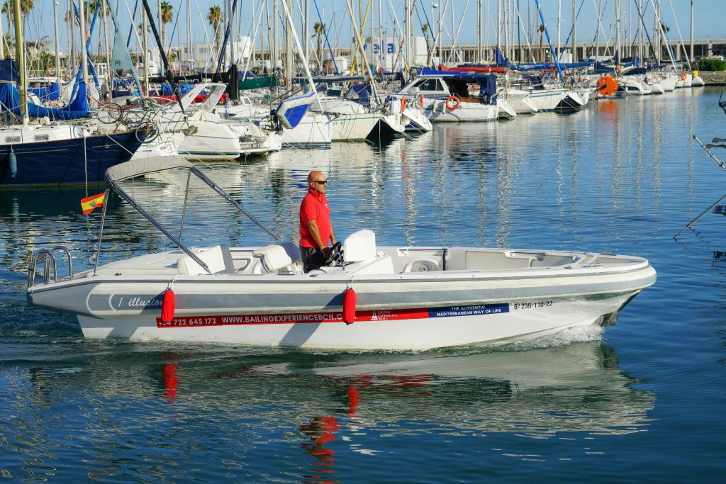 모터보트를 조종하는 빨간색 폴로 셔츠를 입은 남성