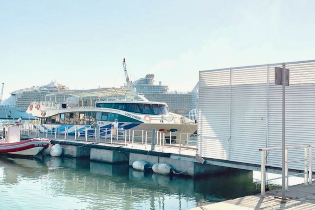 부두 근처에 '바이런 경 (Lord Byron)' 이라는 이름의 여객선이 정박해 있으며, 커다란 유람선이 배경으로 보입니다.