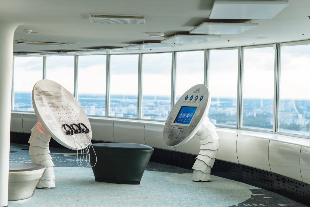 커다란 창문을 통해 도시 전망을 감상할 수 있는 현대적인 실내 전망대에는 인터랙티브한 전시물과 좌석이 마련되어 있습니다.