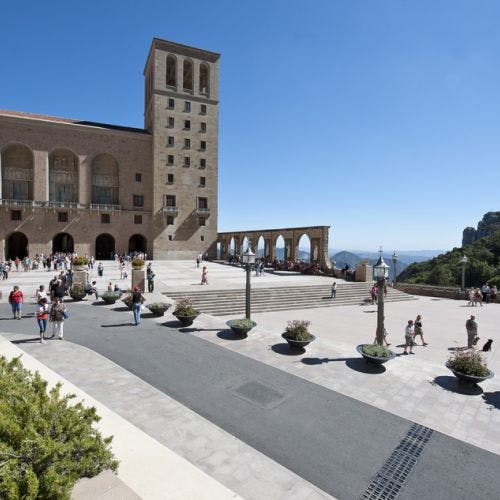 관광객들은 화분이 있는 넓고 탁 트인 광장을 탐험하며 화창한 날에는 아치와 탑이 있는 석조 건물로 이어집니다.