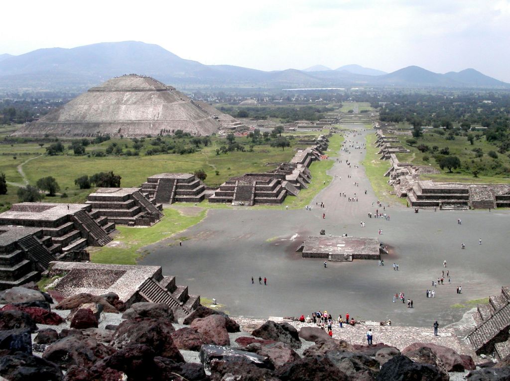 테오티우아칸 (Teotihuacan) 의 고대 피라미드와 건물을 배경으로 죽음의 거리를 걷는 사람들의 모습.