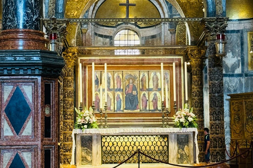 대성당 내부의 화려한 제단으로, 종교적인 그림, 촛불, 꽃꽂이, 정교한 장식이 특징입니다.