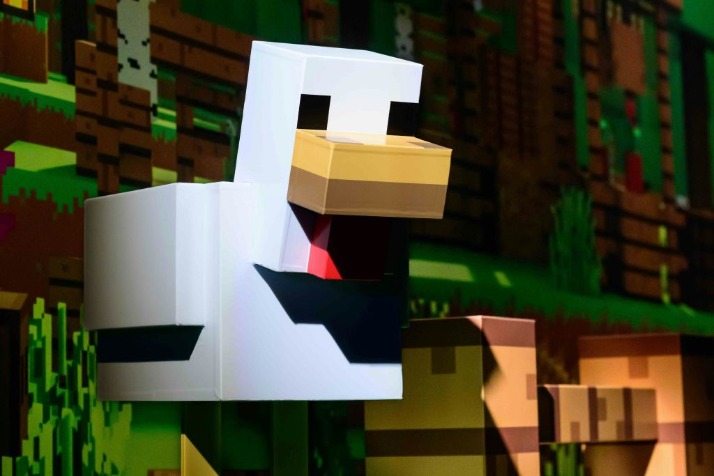 녹색과 갈색 톤을 배경으로 한 게임 환경의 블로키한 픽셀아트 스타일의 치킨입니다.