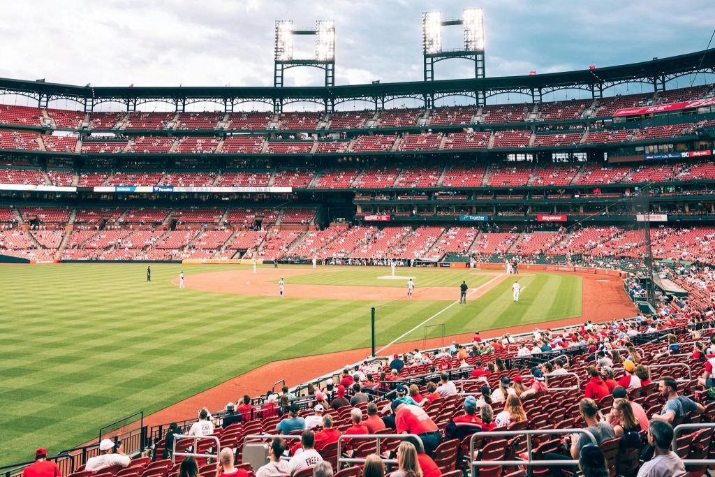 경기장에서 진행 중인 야구 경기로, 경기장에 있는 선수들과 관중들이 스탠드에 앉아 있습니다.