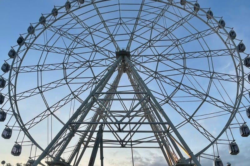 푸른 하늘을 배경으로 금속 프레임워크가 있는 커다란 관람차.