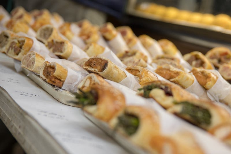 트레이에 표시되는 종이로 포장된 다양한 채워진 페이스트리의 행.