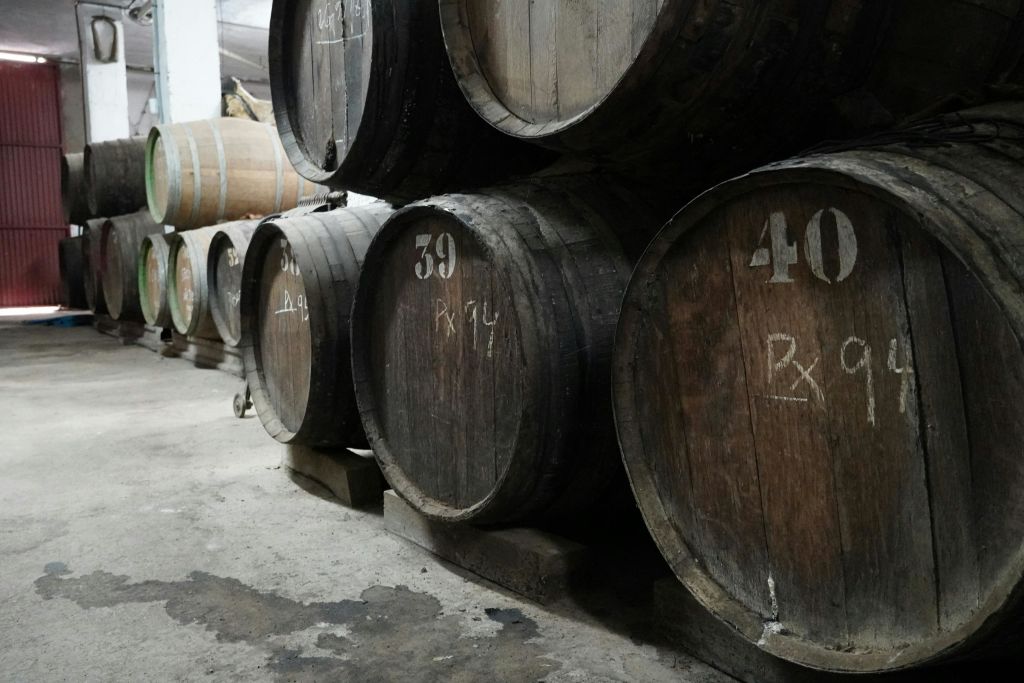 콘크리트 바닥의 지하실에 쌓인 라벨이 붙은 나무 통.