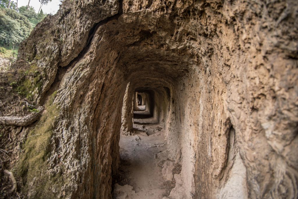 험하고 바위가 많은 벽이 멀리까지 뻗어 있는 좁은 터널로, 시각적 효과를 겹겹이 연출합니다.