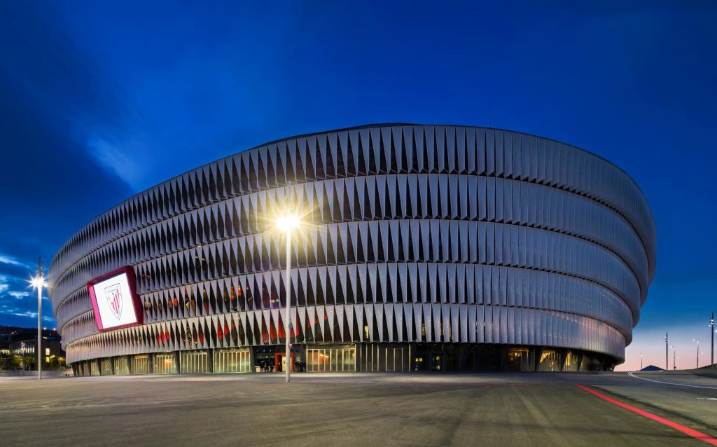 외관에 독특한 수직 슬랫이 있는 현대적인 복층 건물로 해질 무렵 가로등이 비춥니다.