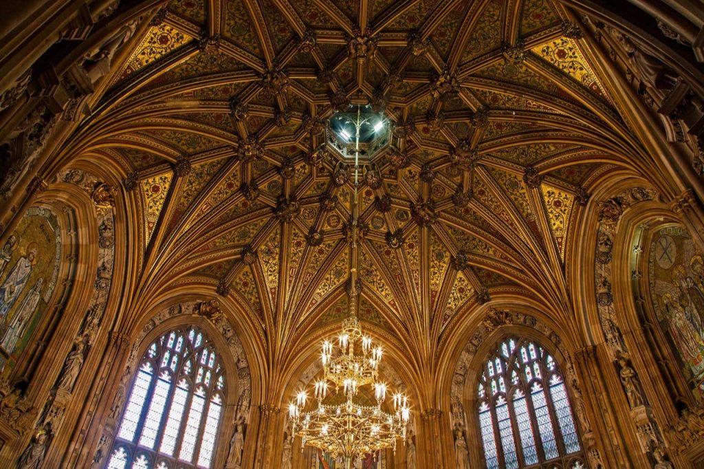 정교한 디테일의 고딕 스타일 천장, 스테인드글라스 창문, 중앙에 걸린 커다란 화려한 샹들리에.