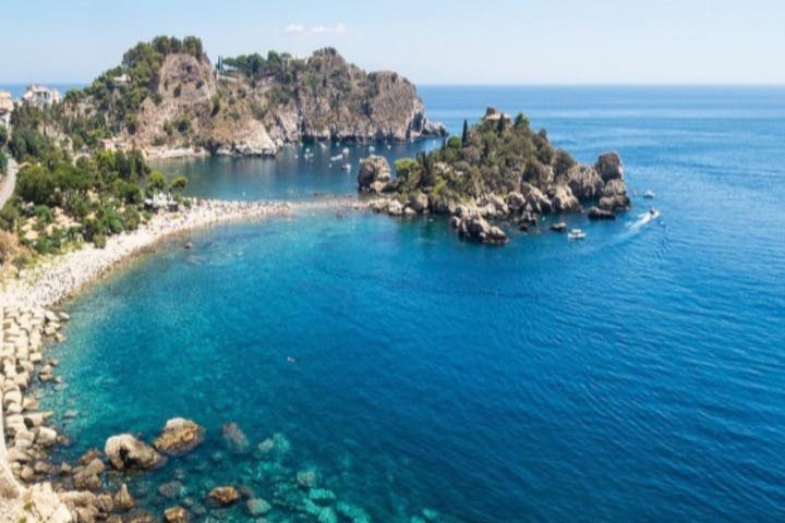 맑고 푸른 물, 바위투성이의 섬, 울창하고 바위투성이의 해안선과 함께 모래 해변이 있는 해안 만의 공중 전망.