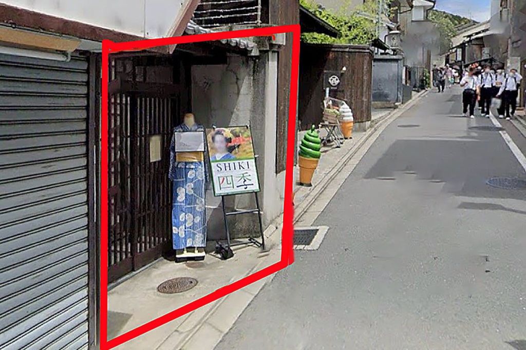 파란색 기모노를 입은 마네킹이 '시키' 라고 적힌 간판 옆에 서 있습니다. 보도를 따라 커다란 아이스크림 콘 조각상 두 개가 보입니다.