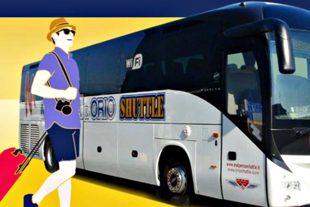 캐주얼한 복장을 한 사람이 카메라를 들고 빨간색 여행 가방을 끌고 '오리오 셔틀' 이라고 적힌 흰색 셔틀 버스를 타고 걸어가고 있습니다.