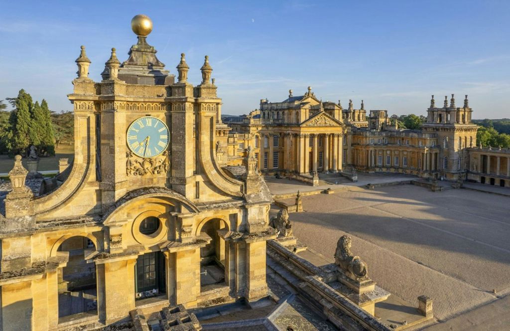청명한 푸른 하늘 아래, 시계탑과 화려한 건물이 있는 화려한 건축물이 있는 유서 깊은 궁전.