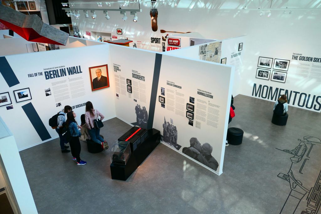 베를린 장벽, 반체제 인사, 정상화에 관한 전시를 관람하는 박물관 방문객들은 정보 패널과 사진을 볼 수 있습니다.