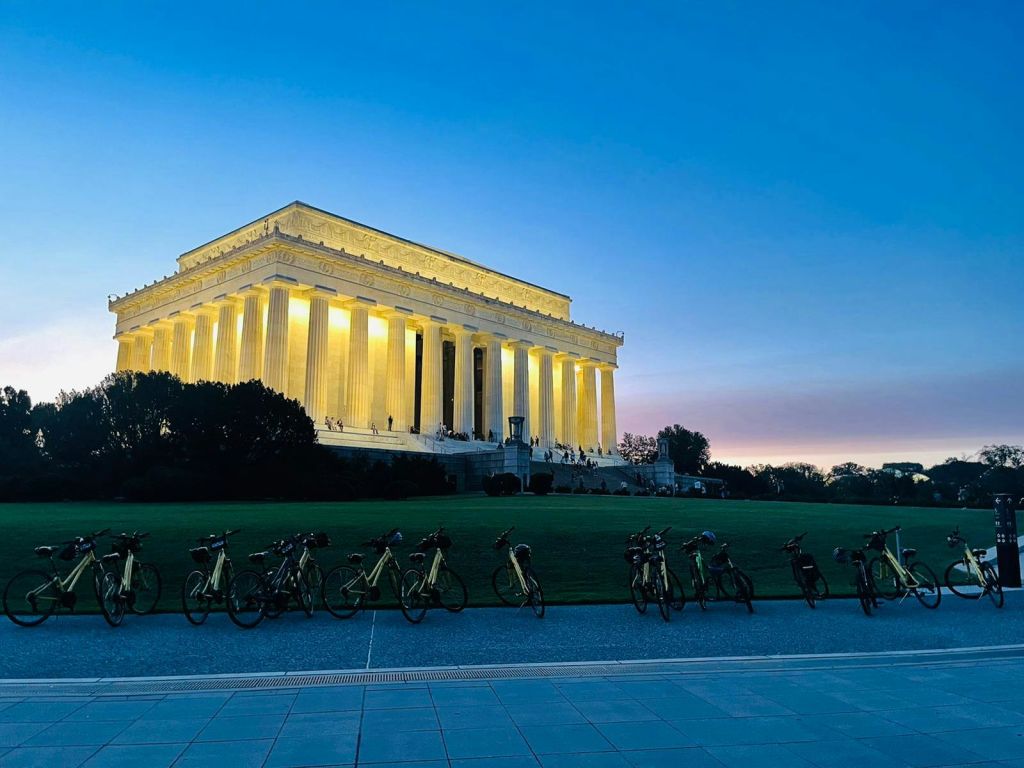 해질 무렵, 전경에 자전거가 늘어서고 맑은 저녁 하늘이 펼쳐진 링컨 기념관.