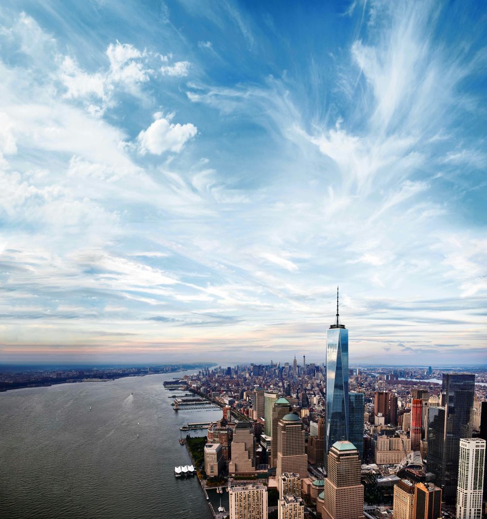 원 월드 트레이드 센터 (One World Trade Center) 와 부분적으로 흐린 하늘 아래 허드슨 강 (Hudson River) 을 포함한 고층 건물이 있는 맨해튼 시내의 공중 전망.