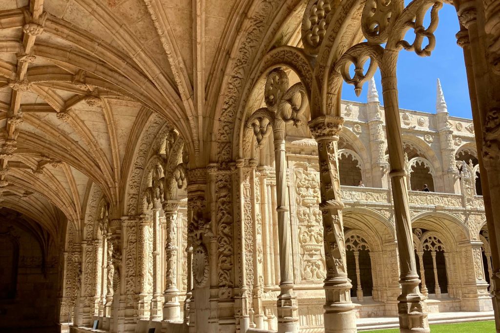 밝고 푸른 하늘 아래 역사적인 건물의 아치와 기둥을 화려하게 조각했다.