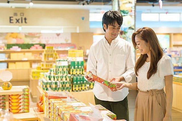 한 남성과 한 여성이 매장에 함께 서서 알록달록하게 포장된 상품을 바라보고 있습니다. 제품 선반이 배경에 표시됩니다.