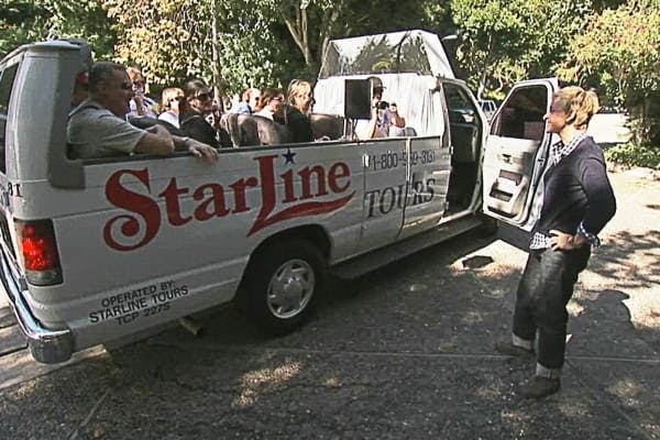 화창한 날 야외에 주차된 좌석 승객이 탑승하는 스타라인 투어 밴입니다.