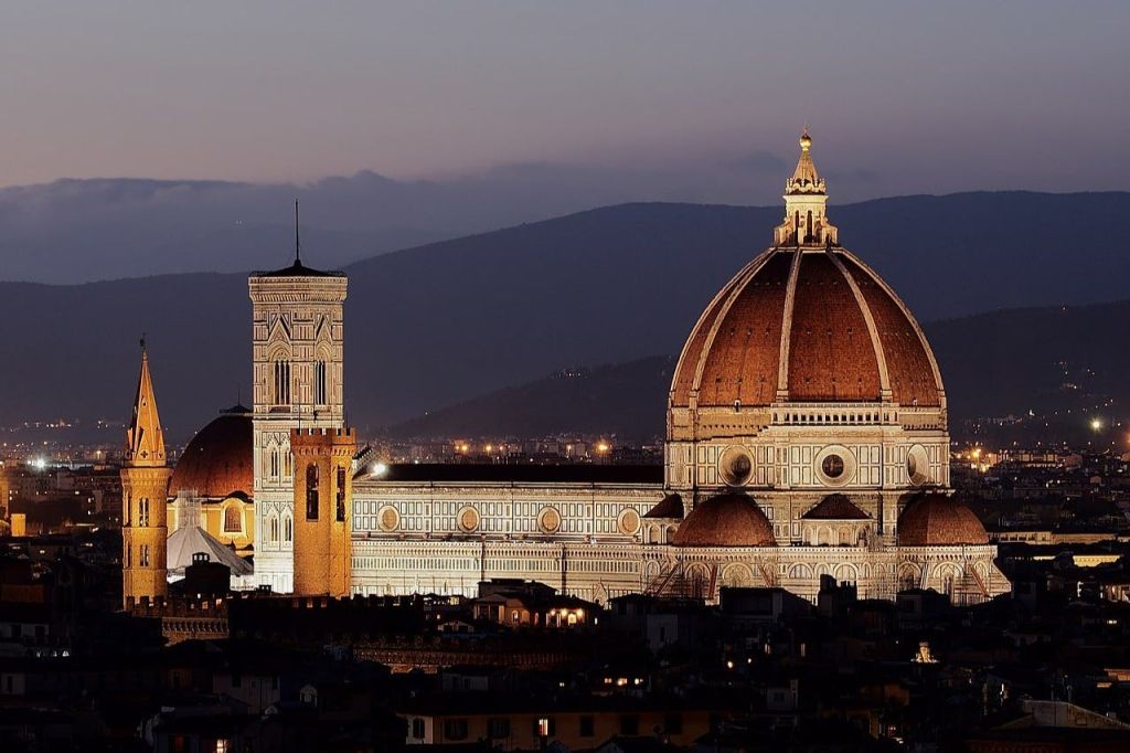해질 무렵 산악 지대를 배경으로 돔과 종탑이 있는 피렌체 대성당.