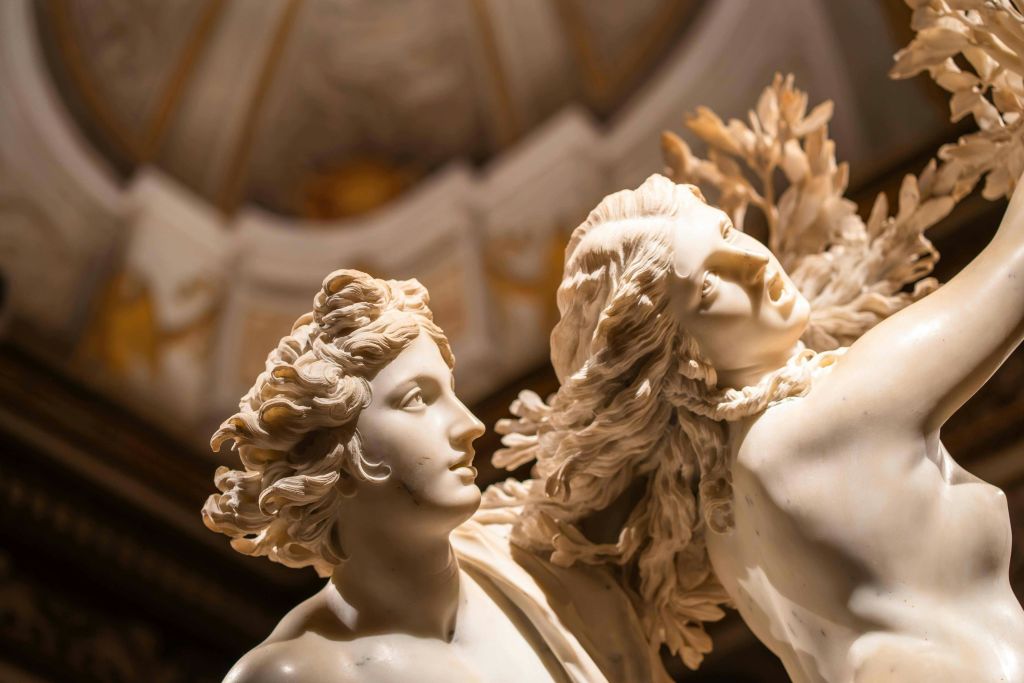 머리카락이 흐르는 두 인물의 대리석 조각이 디테일한 돔형 천장 아래 실내에 전시되어 있습니다.