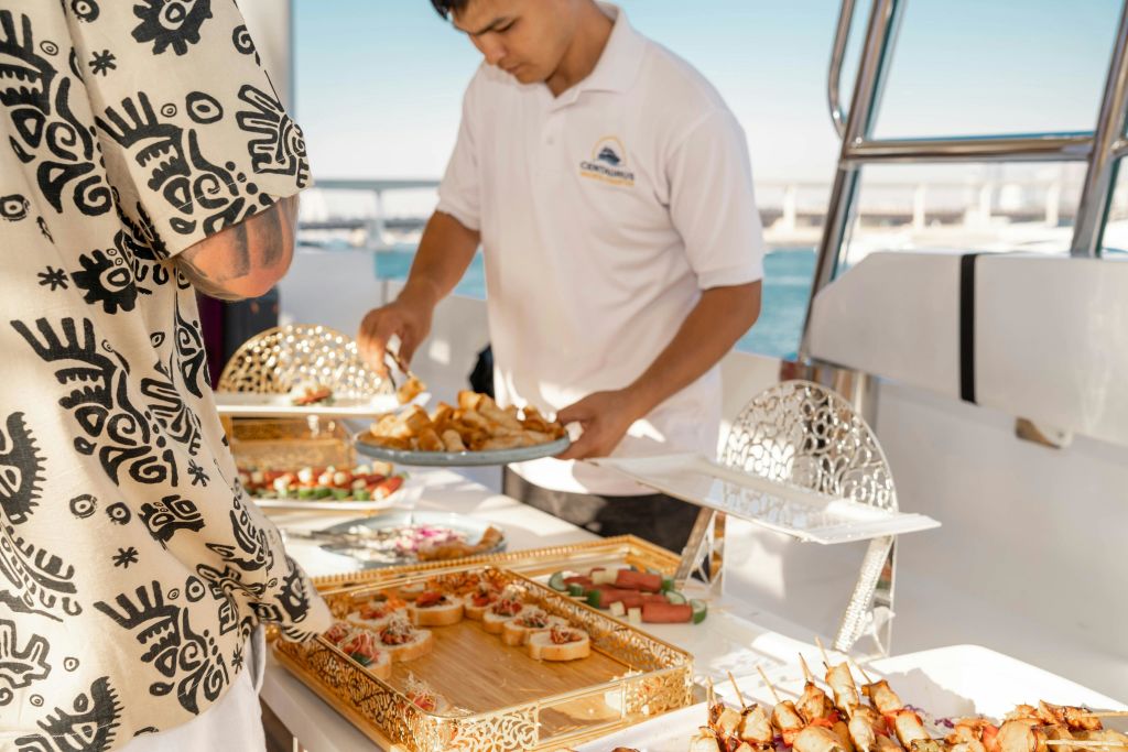 선상에서 게스트에게 음식을 제공하는 요트 승무원