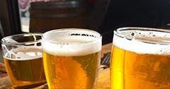 나무 표면에 거품이 많은 상판이 달린 맥주 두 잔.