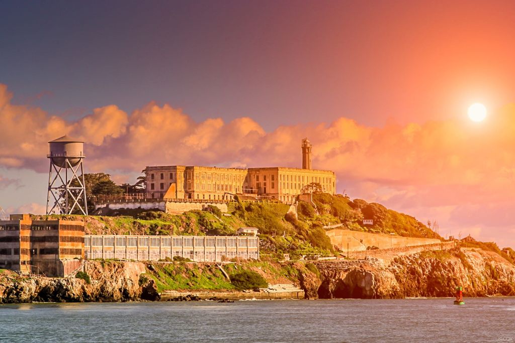 Sail around Alcatraz Island as the warm sun casts an orange glow over it