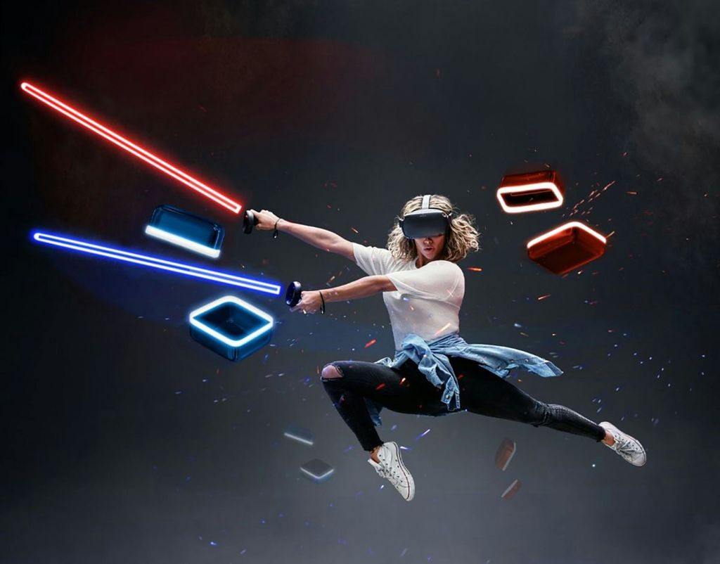 VR 헤드셋을 착용한 사람이 빨간색과 파란색 블록에서 컨트롤러를 점프하고 흔들며 어두운 배경에 불꽃을 생성합니다.