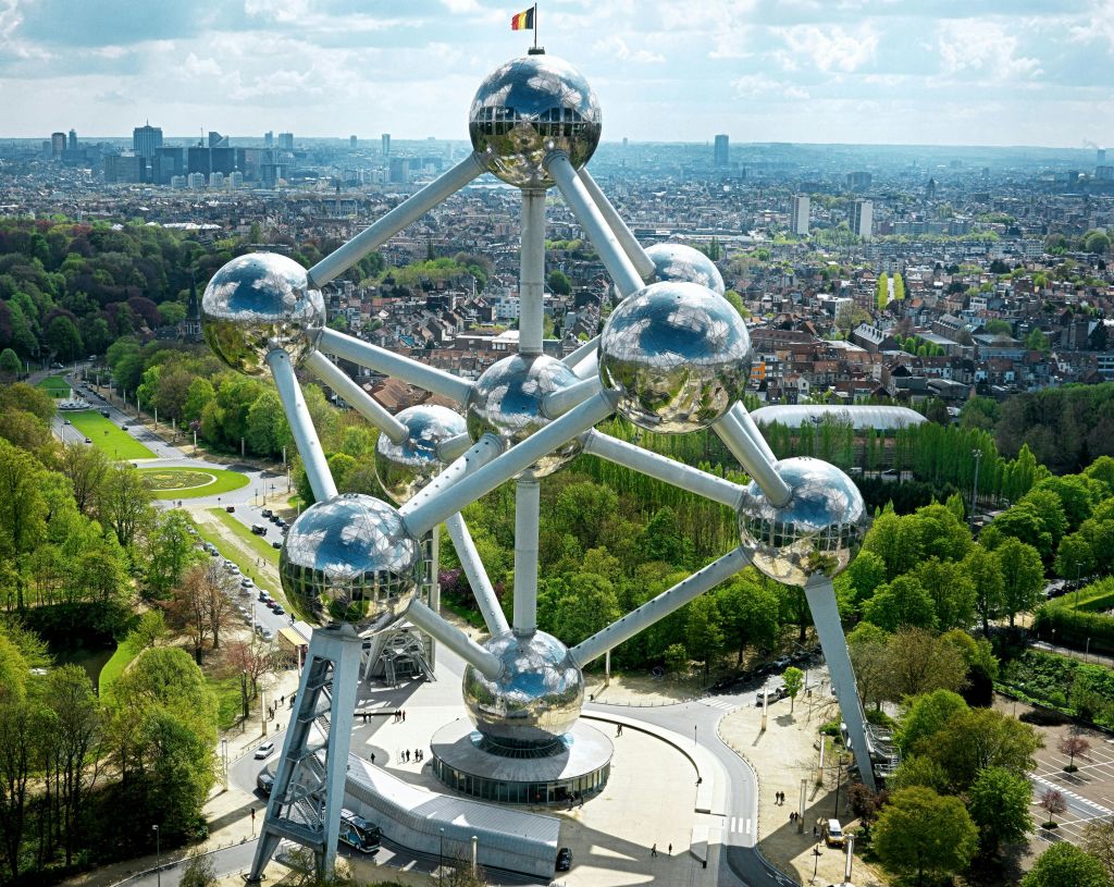 도시 풍경과 녹지로 둘러싸인 반사구와 연결 튜브가 있는 브뤼셀의 아토미움의 공중 전망.