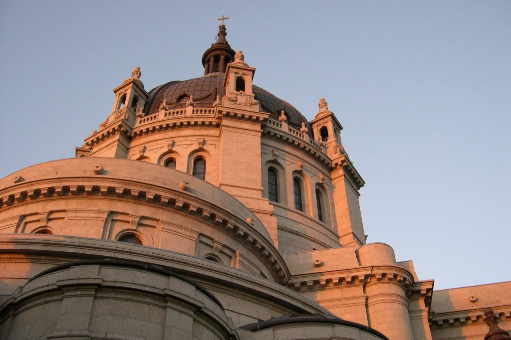 맑은 하늘을 배경으로 따뜻한 햇살을 받으며 화려한 디테일이 돋보이는 돔형 건축 구조물을 가까이서 볼 수 있습니다.