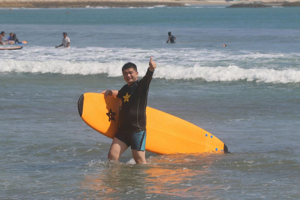 쿠타의 모래 해변에서 행복한 의상 즐기기