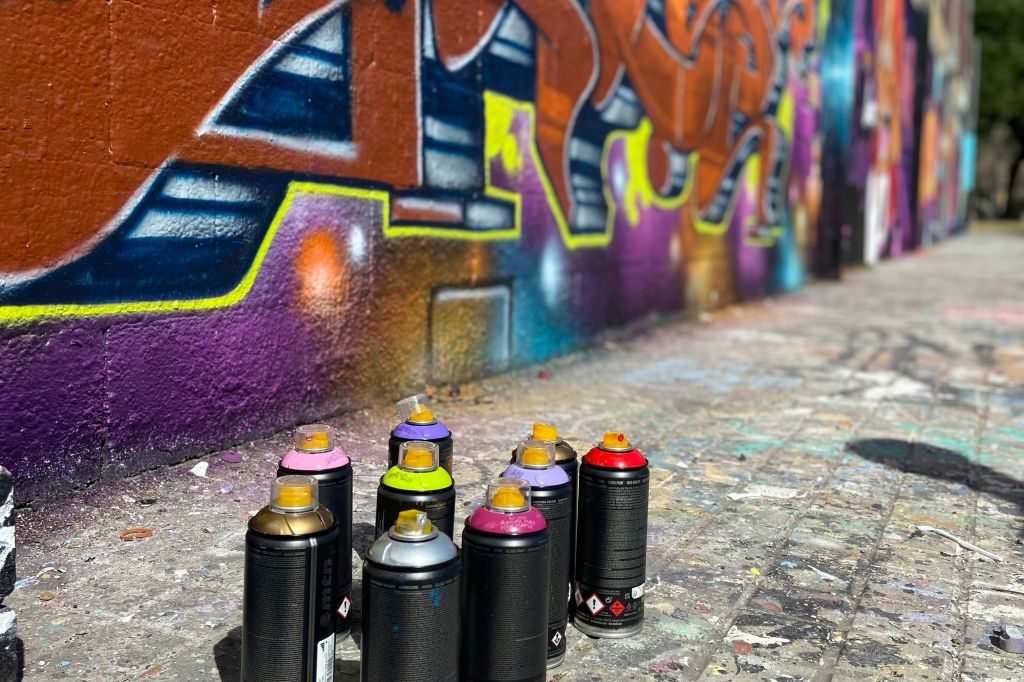 바르셀로나의 더욱 다채로운 벽화 앞에 놓인 다채로운 스프레이 캔