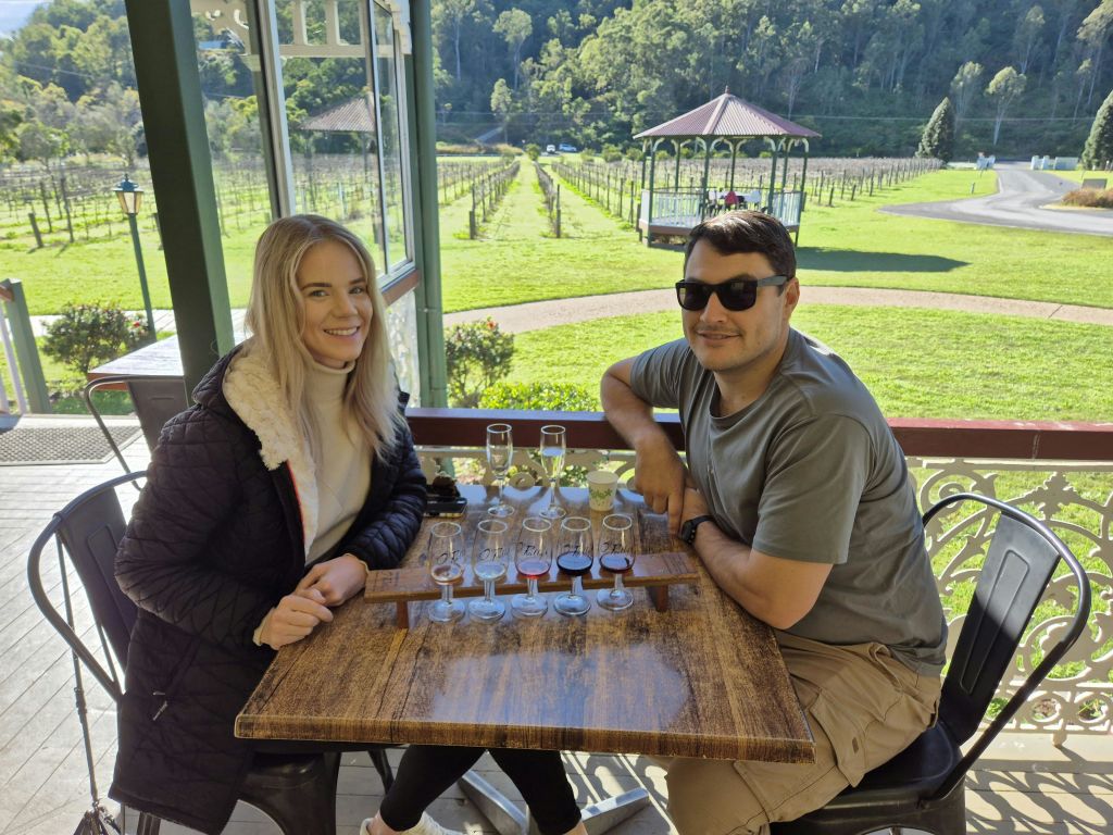 해가 질 무렵 풀밭 위에 떠 있는 줄무늬 열기구. 저 먼 하늘에 또 다른 풍선이 보인다.