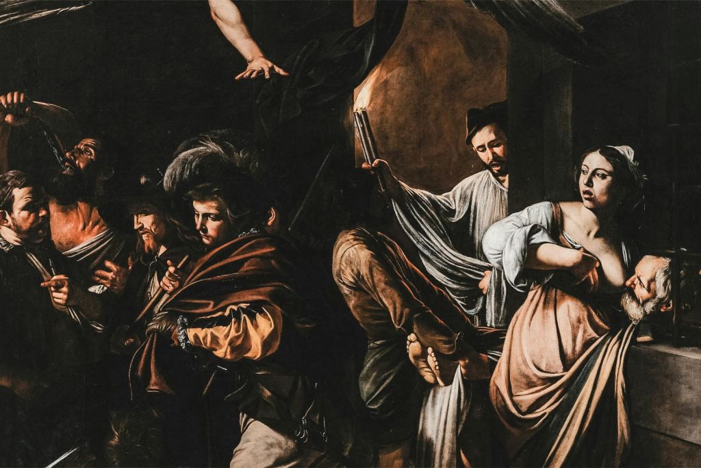 남자의 머리를 잡고 있는 여자를 포함한 여러 사람이 촛불 하나에 불을 붙이는 극적인 장면.