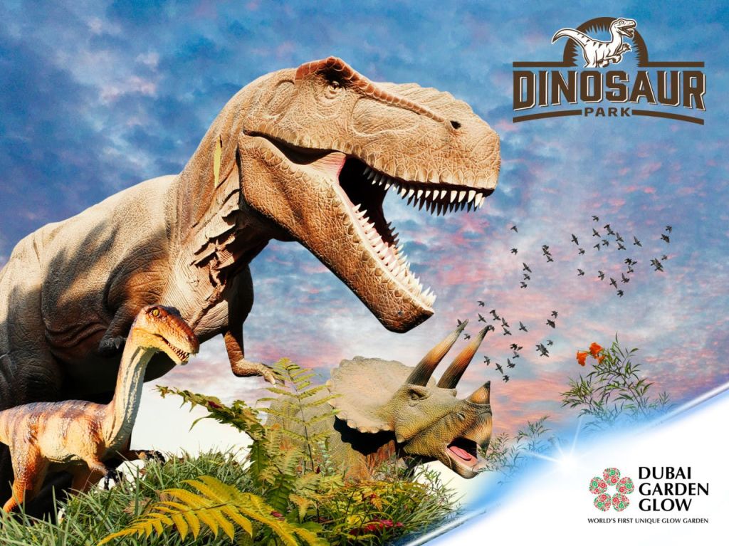 티렉스 (T-Rex) 와 트리케라톱스 (Triceratops) 를 포함한 사실적인 공룡 조각은 하늘에 로고가 있는 단풍으로 둘러싸여 있습니다.