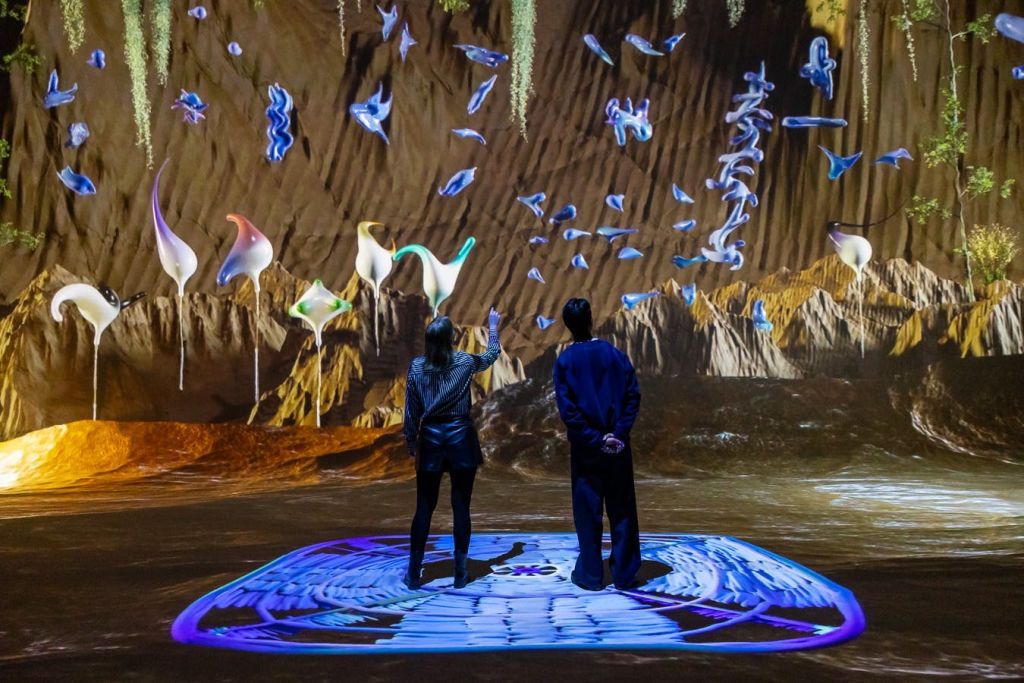 현재 발푸아의 작품을 보여주는 넓은 투사 공간인 Nxt Stage에 두 사람이 서 있습니다.