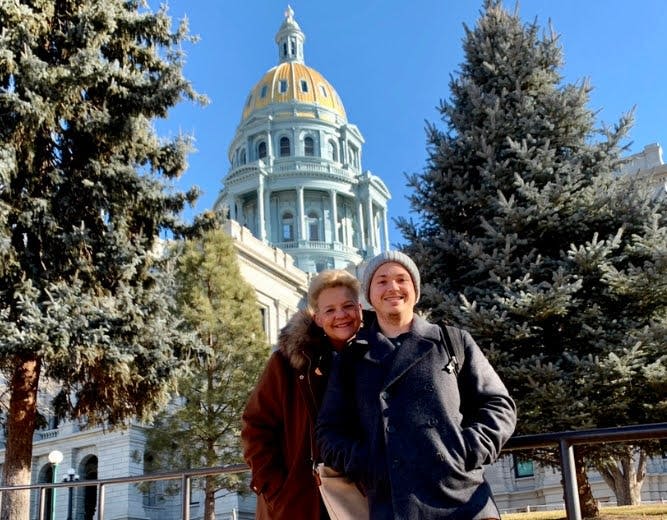 화창한 날에 나무로 둘러싸인 돔형 건물 앞에서 포즈를 취하는 두 사람.