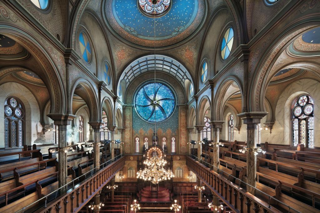아치형 천장, 샹들리에, 커다란 파란색과 별무늬 스테인드글라스 창문이 있는 회당의 화려한 내부.