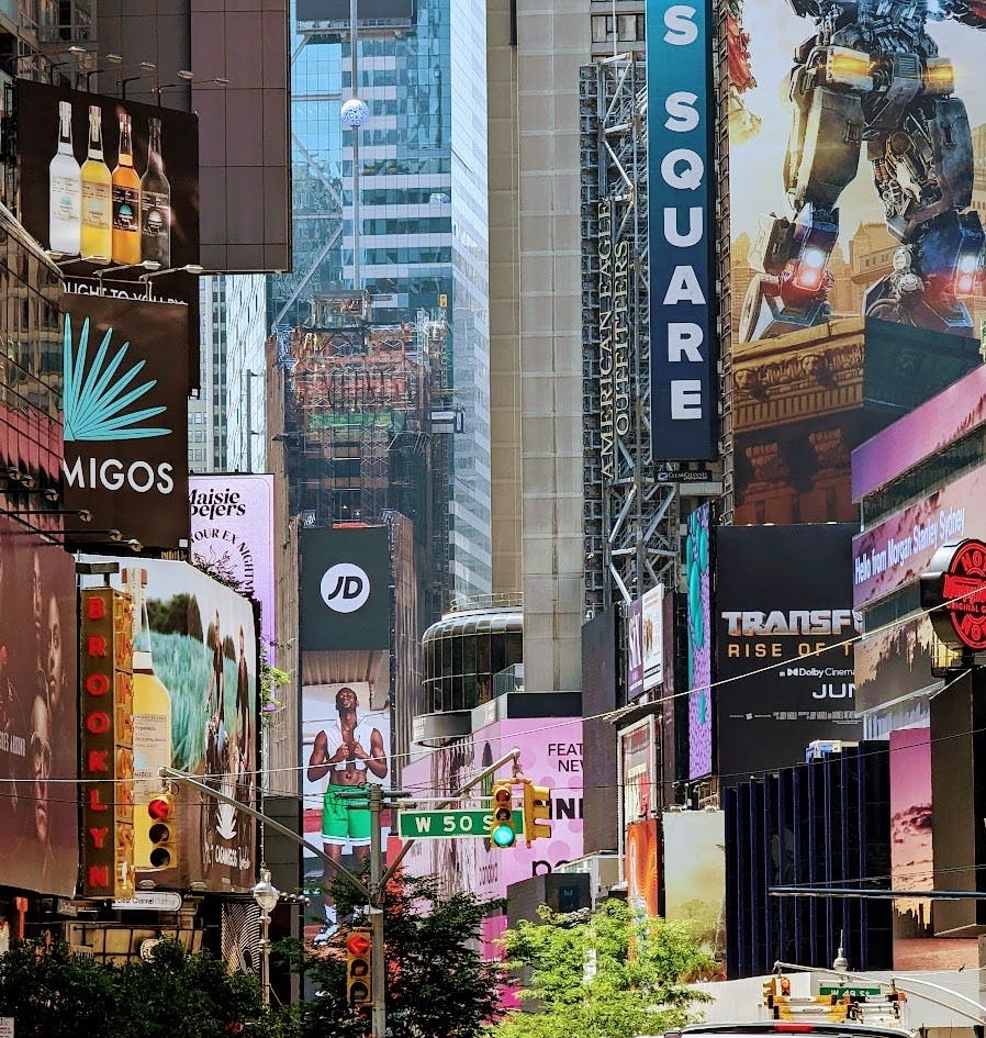 화려한 광고판과 광고로 장식된 높은 건물로 둘러싸인 번화한 도시 거리.