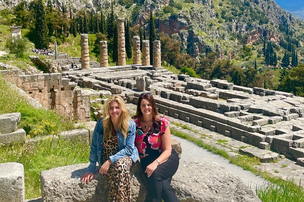 델파이 고고학 유적지를 배경으로 사진을 찍는 게스트