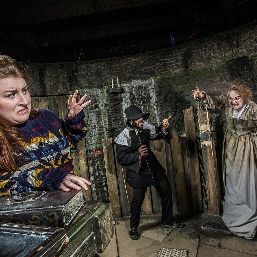 어둡고 던전 같은 분위기의 세 사람은 한 명은 겁에 질린 것처럼 보이고, 한 명은 어두운 시기의 옷을 입고, 다른 한 명은 낡은 드레스를 입고 섬뜩한 표정을 짓고 있습니다.