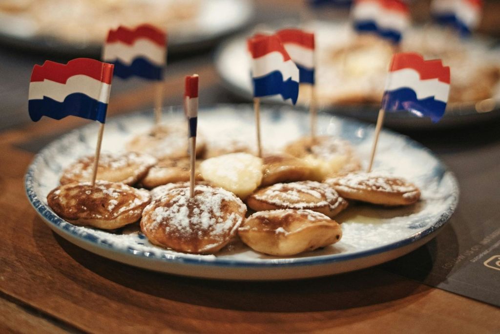 네덜란드 국기를 닮은 작은 깃발을 얹고 설탕 가루를 뿌린 작은 페이스트리 한 접시.
