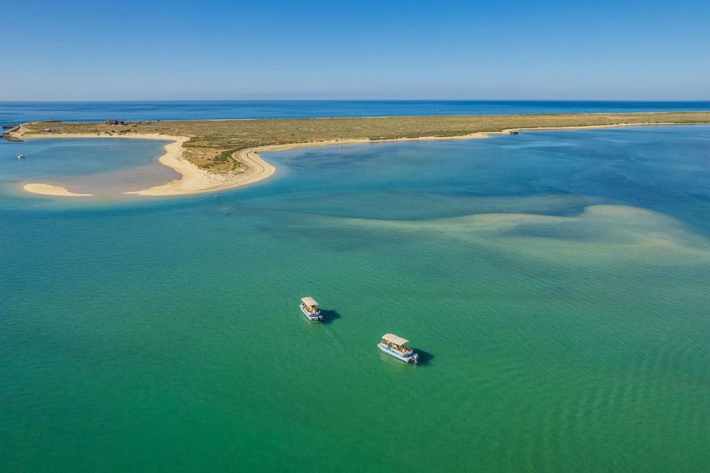 청록색의 맑은 바다와 밝은 푸른 하늘 아래 아름다운 해안 전망을 감상할 수 있는 데세르타 섬 근처의 포르모사마르 보트.
