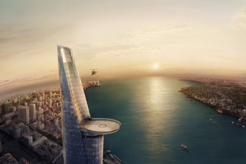 해질 무렵 해안가의 높은 고층빌딩 꼭대기에서 헬리콥터가 헬리콥터에 착륙하고 있습니다. 아래로 보이는 도시 풍경과 물.