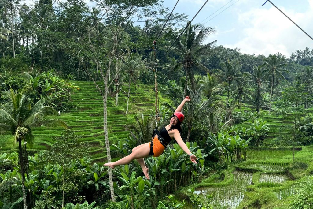 U Fun Field Park의 아름다운 푸른 계단식 논 위에서 행복하게 짚라인을 즐기는 여성